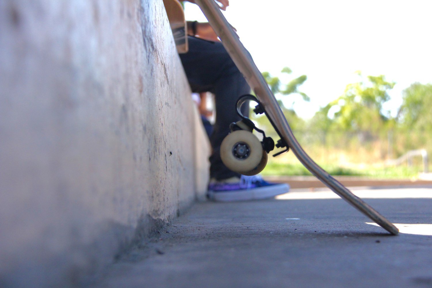 Close-up of an Avenue suspension truck and wheel on a skateboard resting on the ground